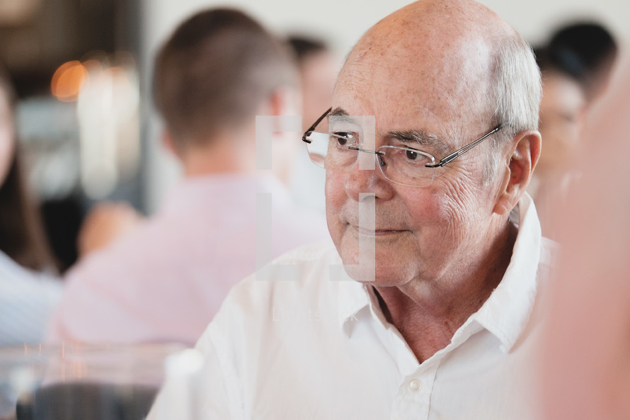 face of an elderly man in glasses 