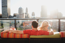 couple sitting on a balcony in a city 