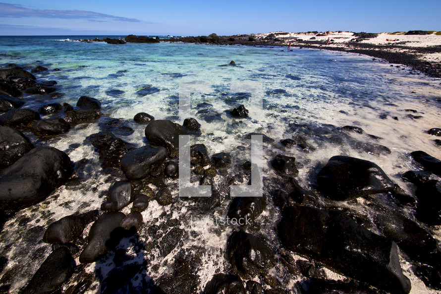 tide washing over rocks along a shore 