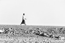 a man walking across the desert in a Ethiopia 
