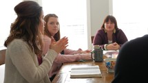 woman talking to a women's group Bible study sitting around a table 