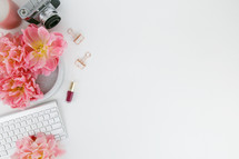nail polish, pink flowers, computer keyboards, clips, camera, candle, white background, desk 