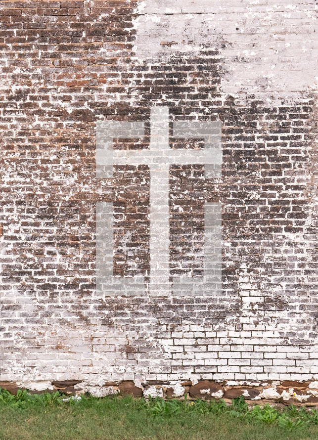 painted cross on an old brick wall 