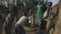 Young children pumping water in African village 