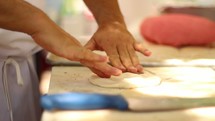 A chef making a pizza dough.