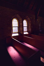 sunlight through windows in a church onto pews