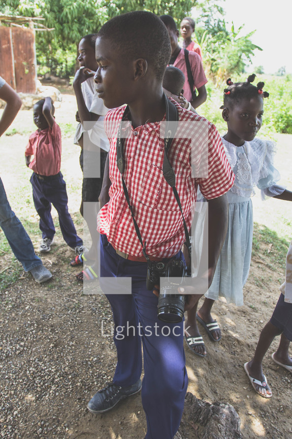 children outdoors in dress clothes in a village 