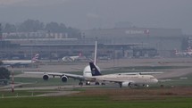 Slow motion video of commercial airplanes moving down a taxiway.