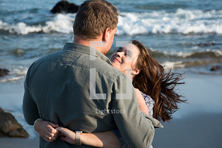 a couple hugging on a beach 