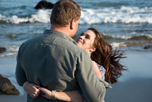 a couple hugging on a beach 