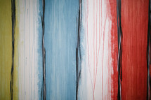 yellow, blue, white, red, black, vertical stripes painted wood background 