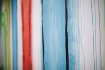 yellow, blue, white, red, black, vertical stripes painted wood background 