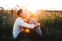 a couple kissing in a field 