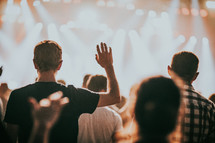 hands raised in worship at a concert in Prague 
