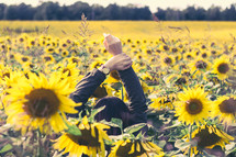 Girl reaching hands in a flower field