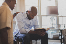 two men in prayer at a Bible study 