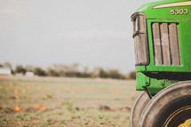 green tractor in a pumpkin patch