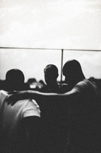 Silhouette of men in a huddle.