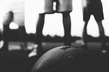 Silhouette of men's legs with a football.