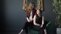 two young women posing on chair for fashion shoot