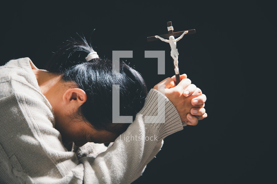 Hands holding a crucifix in prayer