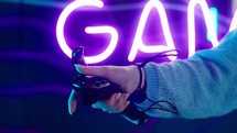 Close up of a woman holding a joystick while playing a virtual reality game.