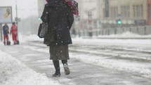 pedestrians walking on a snowy downtown sidewalk 