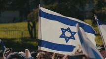 Israeli flag and a crowd of demonstrators