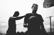 Silhouette of men playing basketball.