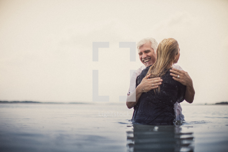 A pastor hugging a young woman after being baptized.