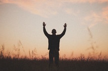 man with his hands raised in worship to God 