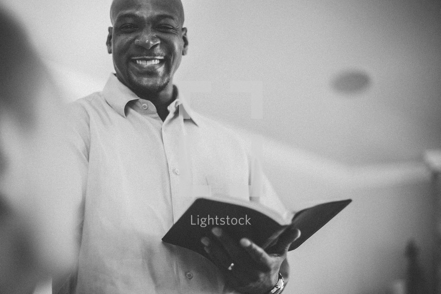 man reading a Bible to others 