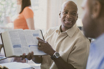 man pointing to scripture at a Bible study 