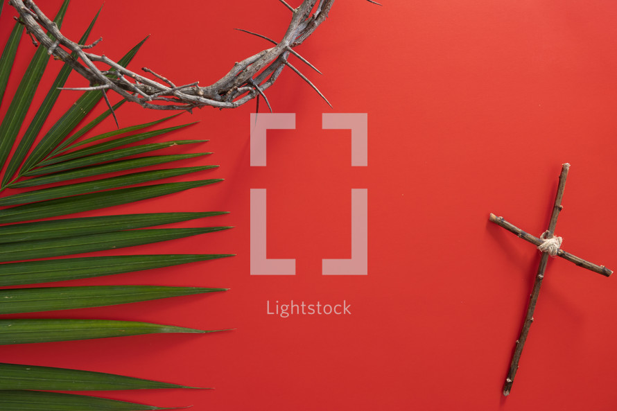palm frond on a red background, crown of thorns, and cross of sticks 