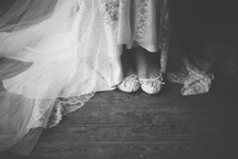 a bride's shoes under her wedding gown 