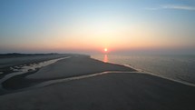 Aerial drone shot of waves of Langeoog Island, Germany at the sunset.
