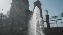 Close up shot of spraying fountain in front of historic Puebla Cathedral and sunlight at summer day,Mexico - Slow motion shot