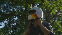 motorcyclist putting on sunglasses and helmet 