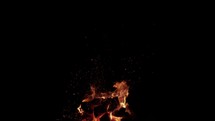 Red hot fire and coals burning wood and logs in camp fire in cinematic slow motion.