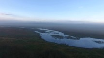Aerial over a wetland marsh with morning fog