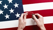 Memorial Day - Close up of American flag background with hands placing dog tags