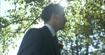 Groom, husband on wedding day wearing tux, suit and boutonniere on wedding day.