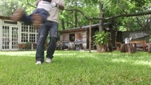 A father swings his son around and around in the back yard.