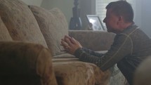 A grown father is praying to God in the comfort of his own home.