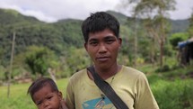 Young Father with Child in Indigenous Asian Village: Exploring Life and Culture