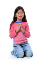 Young girl kneeling with her hands folded in prayer