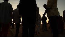 silhouettes of men and women gathering at sunset 