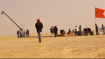 film crews setting up in a desert 