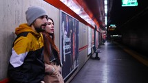 a couple waiting in a subway 