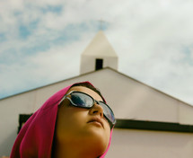 Woman With Pink Headcloth and Church in Background